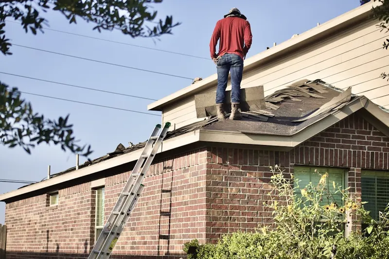 Professional roofer working on a residential roof in Hartfield Acres